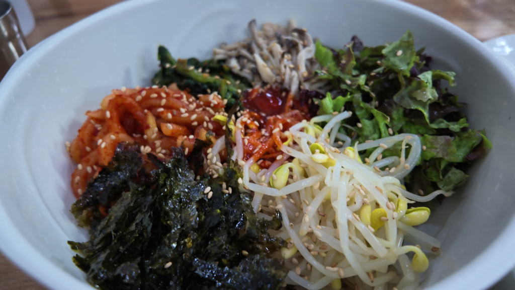 釜山水營站拇指刀削麵店大麥拌飯，裡面有豐富蔬菜