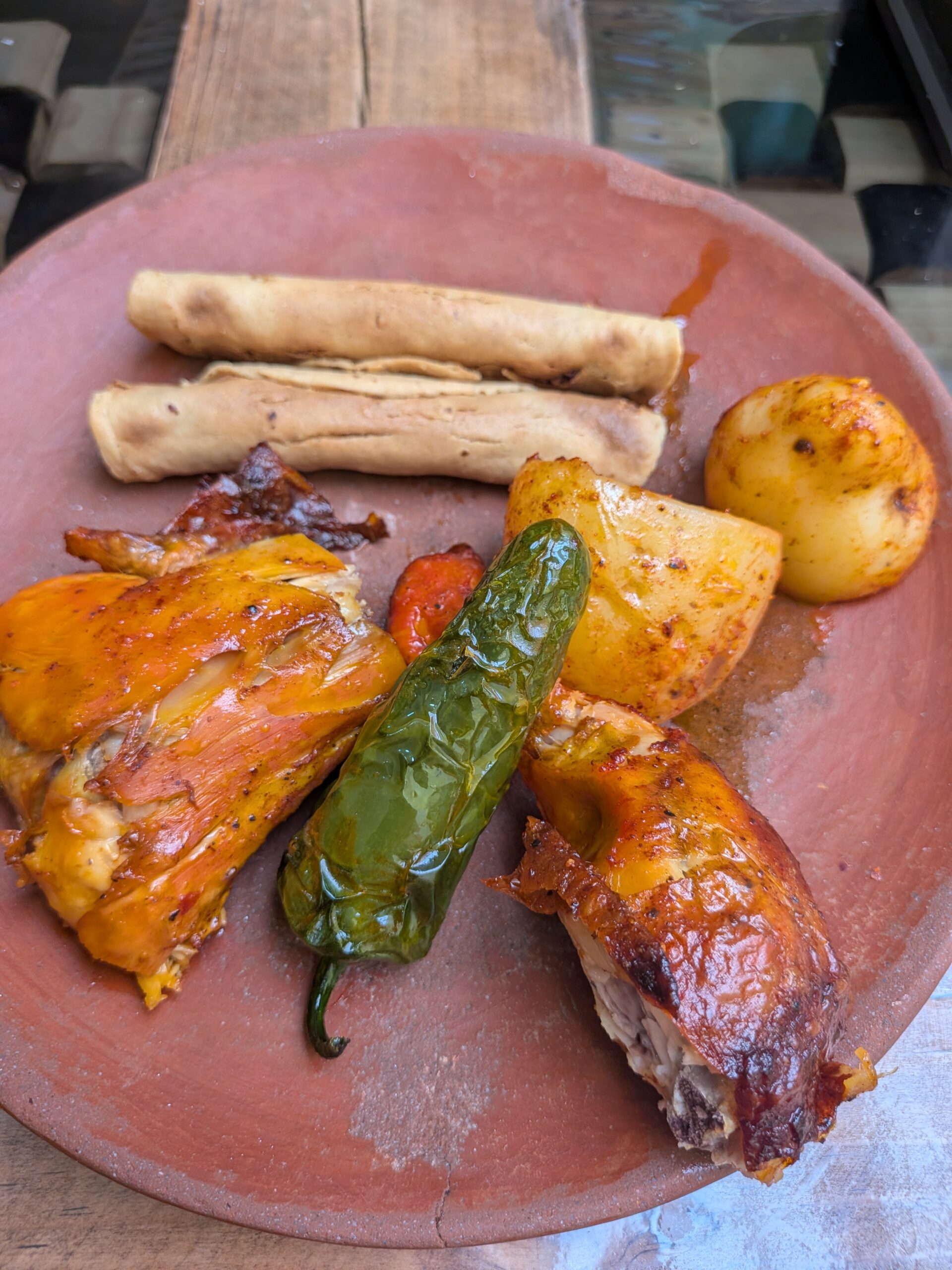 Pollo Pechugón Santo Domingo 的個人烤雞套餐,包含烤雞腿、馬鈴薯塊、沙拉,以及印象深刻的烤辣椒。