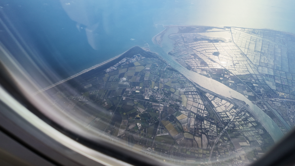 搭乘傳統航空高空俯瞰地面窗景，提醒旅客注意機票是否包含托運行李